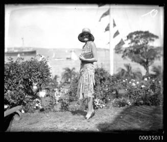 Woman with clutch bag and hat posing for the camera