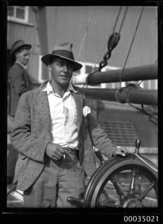 Man at the wheel of the sailing ketch CORWA