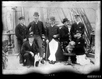 Group portrait of seven men posing on a ship's deck