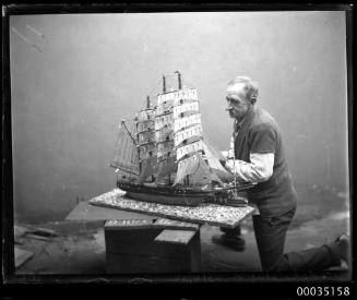 Man with a model of a fully rigged ship