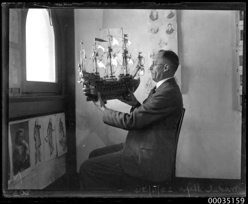 Man holding up a model of 16th century galleon