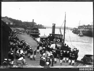 Royal Navy sailors and officers disembark from ferries at Woolloomooloo Bay in Sydney