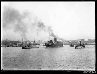 Tug towing twin funnel passenger ship