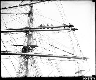 Crewmen attending sails on mast of WINTERHUDE.