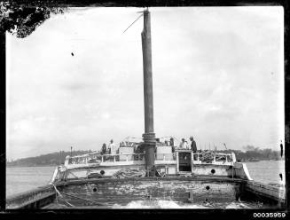 View of INCA on deck with broken mast and workmen.