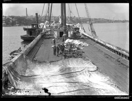 Deck view of INCA showing workmen removing rigging and masts.