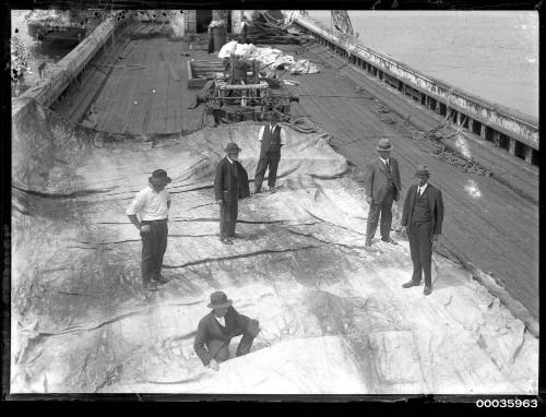 Five men standing on a sail on board of INCA.