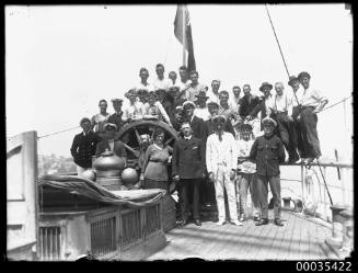 Large group of people at ship wheel possibly MARQUIS OF CLYDSDALE (ex DUKE OF HAMILTON)