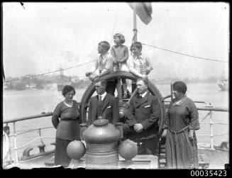 Group of people at ship wheel possibly MARQUIS OF CLYDSDALE (ex DUKE OF HAMILTON)