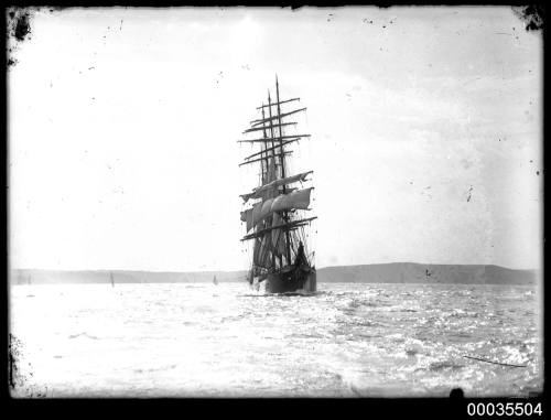 Four masted ship under partial sail leaving Sydney Harbour