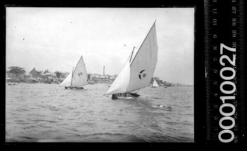 Two 16-foot skiffs near Balmain, Sydney, one displaying a crescent and the other an emblem of a double bar