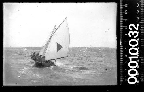 14-footer displaying a triangle emblem with Shark Island lighthouse in the background, Sydney Harbour