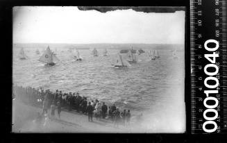 Spectators gather to watch the start of an 18-footer race off Clark Island, Sydney Harbour