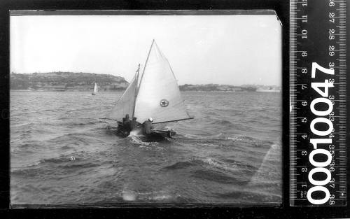 16-foot skiff sailing on Sydney Harbour and displaying an emblem of a star within a circle