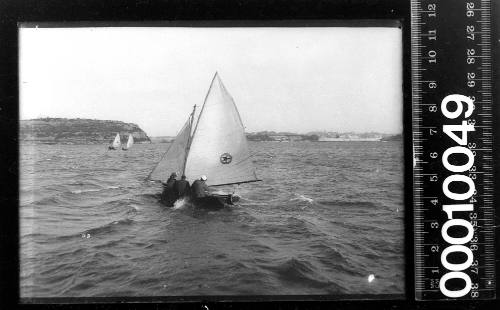 16-foot skiff featuring a star within an circle on the mainsail sailing past Balls Head, Sydney Harbour