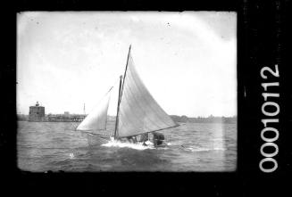 Open clinker dinghy sailing past Fort Denison, Sydney Harbour