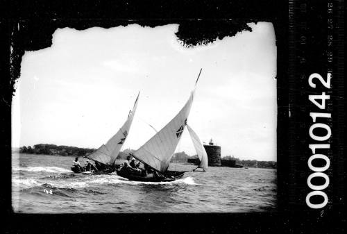 Two 16-foot skiffs sailing past Fort Denison, Sydney Harbour