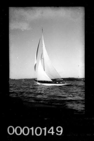 Portside view of a yacht on Sydney Harbour with a steam ferry partially visible in the background