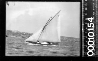 Portside view of a yacht with the number '5' featured on the gunter mainsail, Sydney Harbour