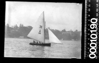 16-foot skiff displaying a triangular emblem and the number '38' on the mainsail, Sydney Harbour