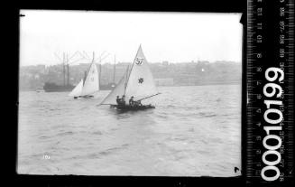 Two 16-foot skiffs racing past Balmain, Sydney Harbour