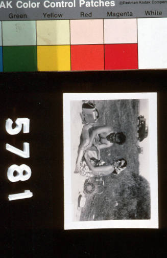 Beach holiday, woman and a man in swimming costumes on picnic blanket