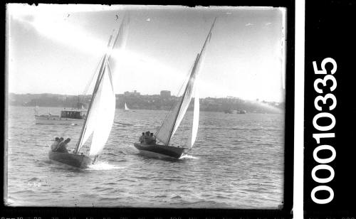 Two 21-foot restricted class yachts on Sydney Harbour with a motorboat in the background