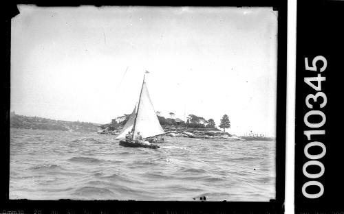 Small bermudan-rigged skiff sailing near Shark Island, Sydney Harbour