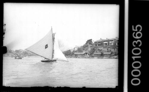 14-footer on Sydney Harbour featuring a diamond emblem with a central horizontal stripe