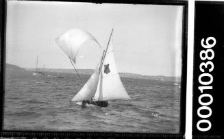 16-foot skiff on Sydney Harbour displaying an emblem of a shield crossed diagonally with a stripe