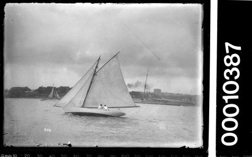 Small yacht on Sydney Harbour, sailing close to a shoreline