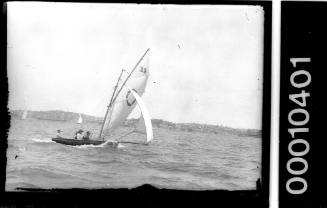 16-foot skiff on Sydney Harbour with a life ring emblem on the mainsail