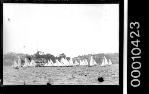 Large fleet of 16-foot skiffs manoevring for a start at Clark Island