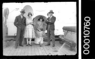 Two couples posing on a ship's deck