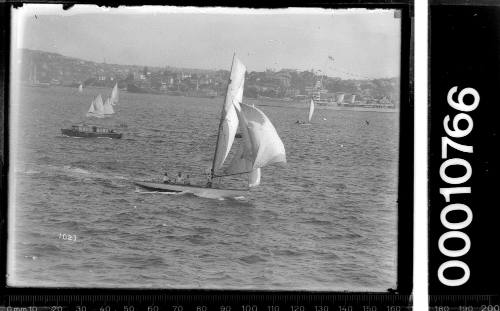 Sailing vessel on Sydney Harbour with other vessels and an ocean liner in the background