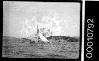 18-foot skiff HC PRESS with billowing spinnaker sailing on Sydey Harbour