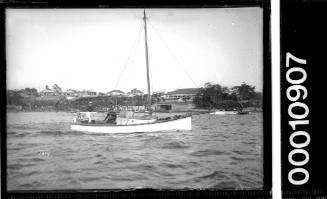 A half-cabin yacht motoring past the St George Motor Boat Club