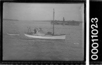 Double-ended motor sailer on Sydney Harbour with a ferry in the background