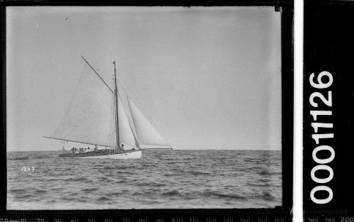 yacht towing dinghy on open sea, possibly near Sydney Heads