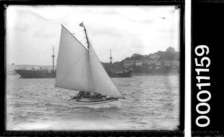 Raised-deck gaff sloop sailing near shoreline, Sydney Harbour