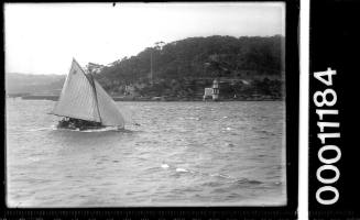 Skiff sailing near Bradley's Head light, Sydney Harbour