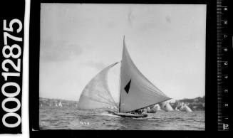 Yacht with a dark triangle emblem on the mainsail, Sydney Harbour