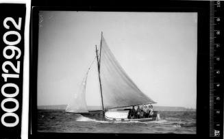 Single masted yacht under sail with six occupants onboard, Sydney Harbour