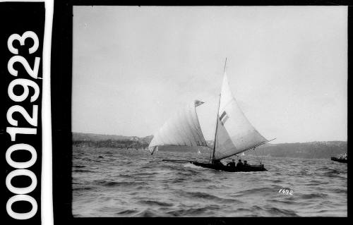 Yacht with a tri-coloured rectangle emblem on the mainsail, Sydney Harbour