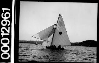 Yacht with dark circle emblem on the mainsail, sailing near Bradleys Head, Sydney Harbour
