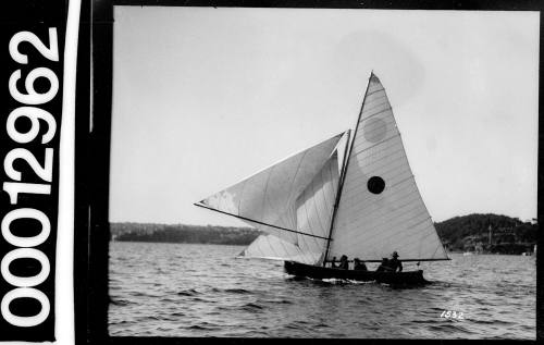 Yacht with dark circle emblem on the mainsail, sailing near Bradleys Head, Sydney Harbour