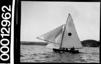 Yacht with dark circle emblem on the mainsail, sailing near Bradleys Head, Sydney Harbour