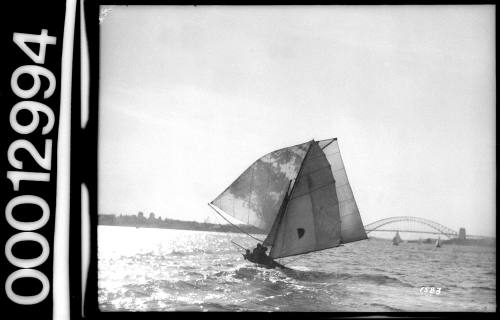 Sailing vessel with a half circle emblem on the mainsail sailing near the Sydney Harbour Bridge