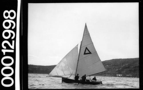 Yacht on Sydney Harbour with a triangle emblem on the mainsail, Sydney Harbour