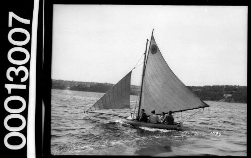 Yacht with a circle emblem on the mainsail and four people visible onboard, Sydney Harbour